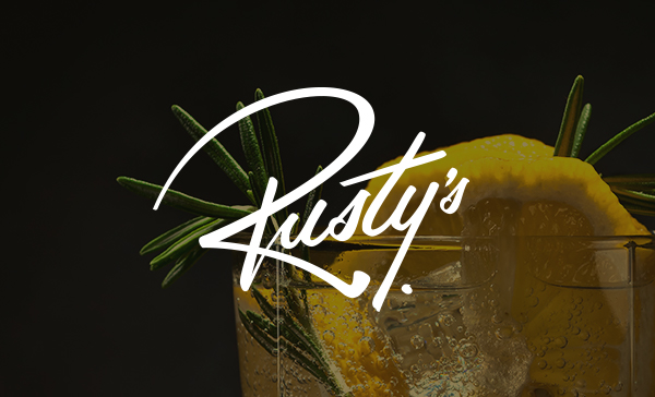 Cocktail With Herb Garnish And The Word Rusty's Overlaid